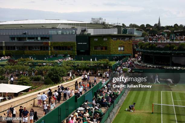 Spectators watch on as Centre Court can be seen during day seven of The Championships Wimbledon 2023 at All England Lawn Tennis and Croquet Club on...