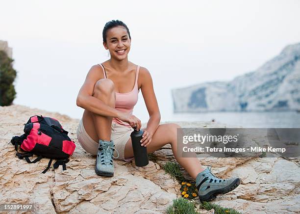 france, marseille, female hiker resting on rocky beach - marseille france stock pictures, royalty-free photos & images