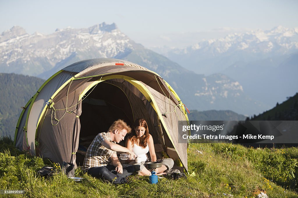 Switzerland, Leysin, Hikers preparing breakfast on Alpine meadow