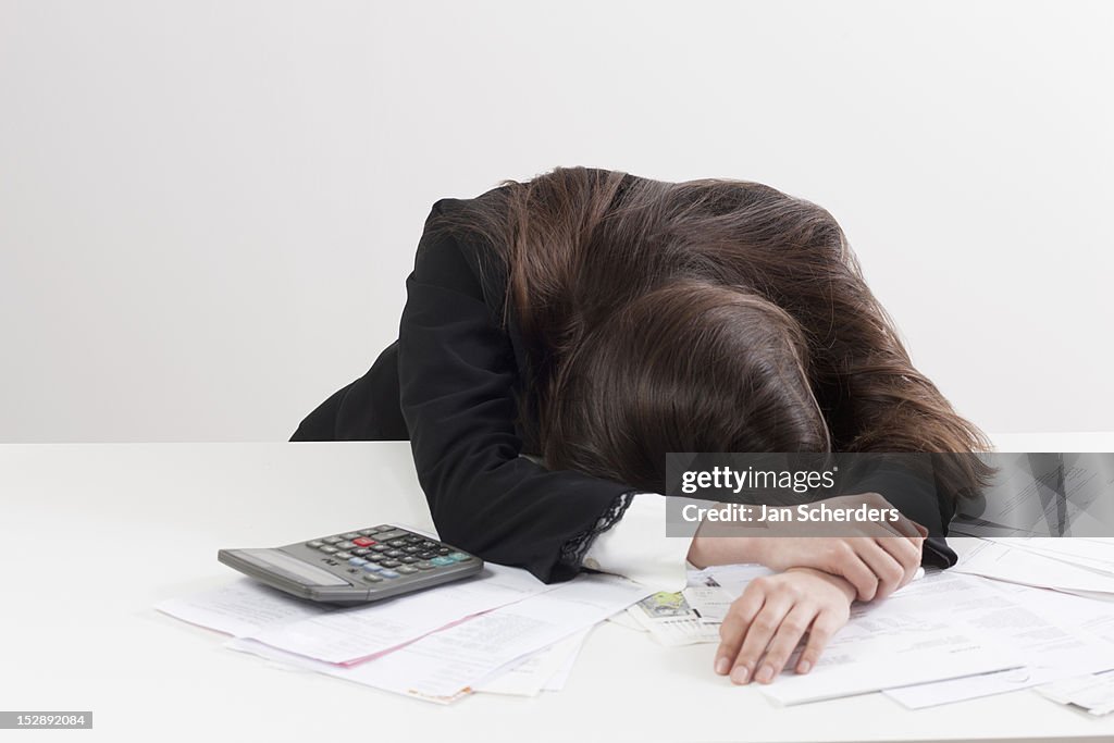 Studio shot of businesswoman with calculator and bills