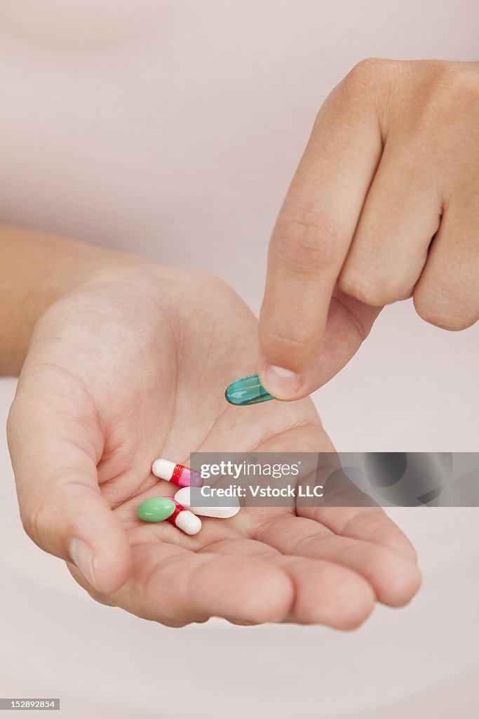 Young woman holding capsules