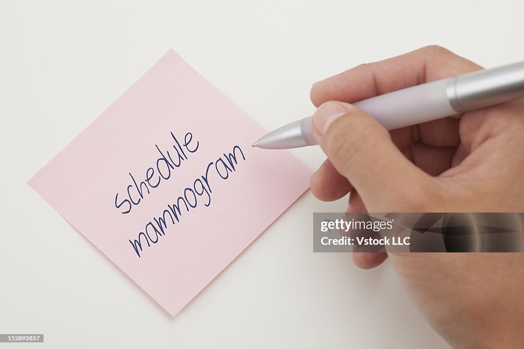 Close-up of young woman writing note