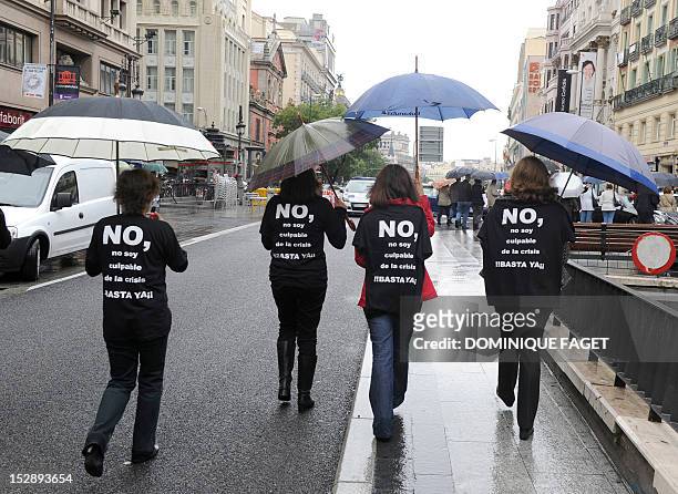 Government employees with t-shirts thats read "No, I am not guilty of the crisis, stop" take part in a demonstration against the Spanish government's...