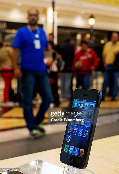 An Apple Inc. IPhone 5 sits on display inside the Apple store at the Gran Plaza 2 shopping mall in Majadahonda, near Madrid, Spain, on Friday, Sept....