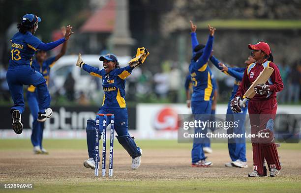 Anisa Mohammed of West Indies looks dejected as Deepika Rasangika and Dilani Manodara of Sri Lanka celebrate their victory during the ICC Women's...