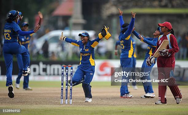 Anisa Mohammed of West Indies looks dejected as Deepika Rasangika and Dilani Manodara of Sri Lanka celebrate their victory during the ICC Women's...