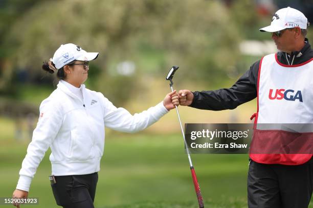 Rose Zhang of the United States reacts with her caddie Jason Gilroyed after making birdie on the fourth green during the final round of the 78th U.S....