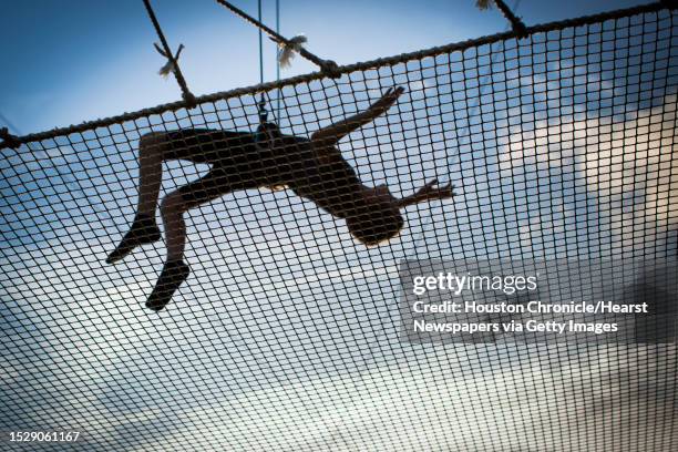 Corbin Adkins of Houston lets go of the trapeze to be catch by the safety net during a trapeze class at Trapeze Texas in Houston, Thursday, May 28,...