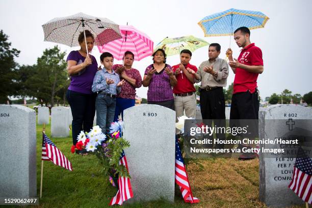 Gloria Sorto, Anthony Hernandez, Matilda Rodas, Carmen Pacheco, Ricardo Lopez, Carlos Sorto and William Sorto, pray at the grave of John Carlos Sorto...