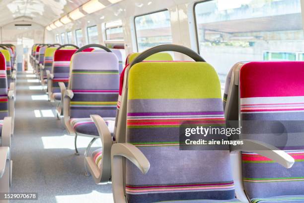 seats in order with colorful pattern inside the paris subway, on the sides there are windows through which the sun enters and on the top there are lamps. - empty seat photos et images de collection