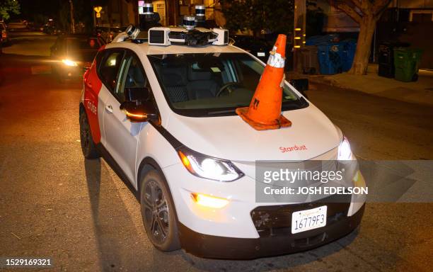 Members of SafeStreetRebel, a group of anonymous anti-car activists, placed a traffic cone on a self-driving robotaxi to disable it in San Francisco,...