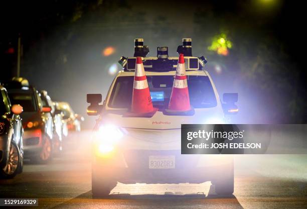 Members of SafeStreetRebel, a group of anonymous anti-car activists, placed traffic cones on a self-driving robotaxi to disable it in San Francisco,...