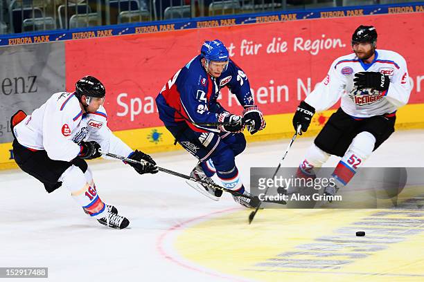 Denis Reul of Mannheim is challenged by Eric Chouinard and Sven Butenschoen of Ice Tigers during the DEL match between Adler Mannheim and Thomas Sabo...