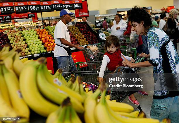 Customer Thalia Veintimilla, right, daughter Aliya Chiriboga shop for produce during the grand opening of a Wal-Mart Stores Inc. Location in Panorama...