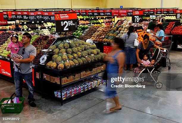 Customers shop for produce during the grand opening of a Wal-Mart Stores Inc. Location in Panorama City, California, U.S., on Friday, Sept. 28, 2012....
