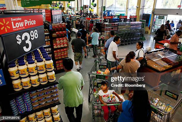 Customers wait in line to check out during the grand opening of a Wal-Mart Stores Inc. Location in Panorama City, California, U.S., on Friday, Sept....