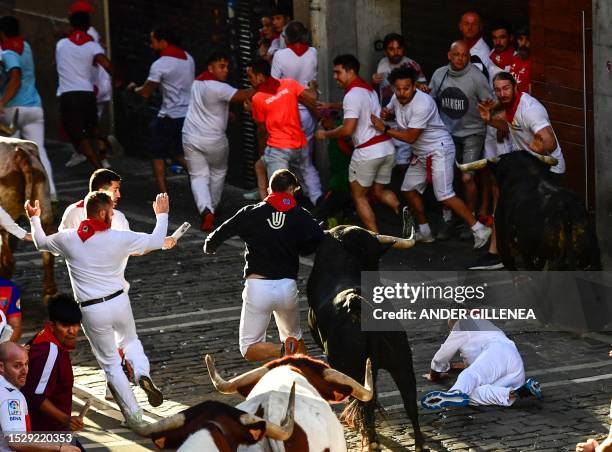 Participant falls as he runs ahead of bulls during the "encierro" of the San Fermin festival in Pamplona, northern Spain, on July 13, 2023. Thousands...