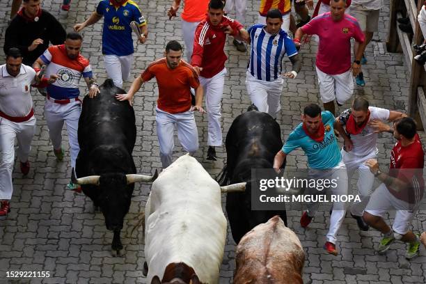 Participants run ahead of bulls during the "encierro" of the San Fermin festival in Pamplona, northern Spain, on July 13, 2023. Thousands of people...