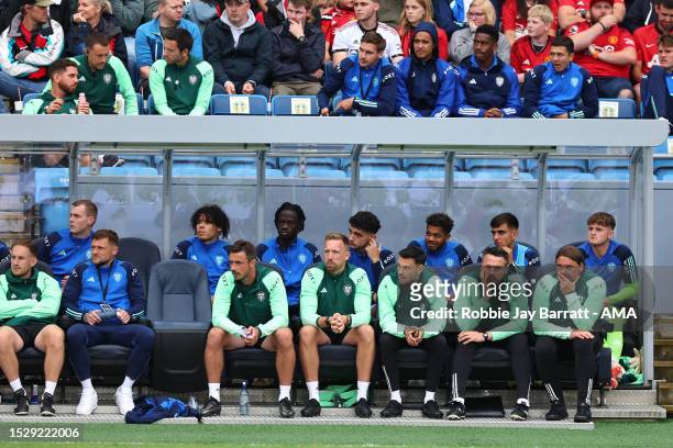 Daniel Farke the head coach / manager of Leeds United sat in the dugout with his staff during the Pre-Season Friendly fixture between Manchester...