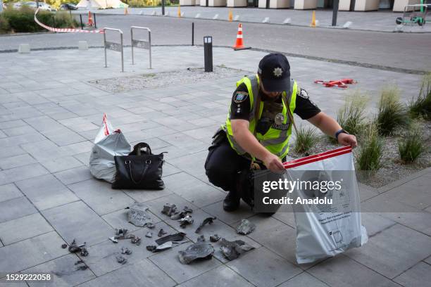 Ukrainian police officer inspects the fragments in front of the damaged residential building after Russian drone attack in Kyiv, Ukraine amid...