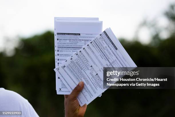 Muhammed Nasrullah hold Texas voter registration applications for distribution at a food distribution event, Friday, Sept. 25 in Houston. Nasrullah...