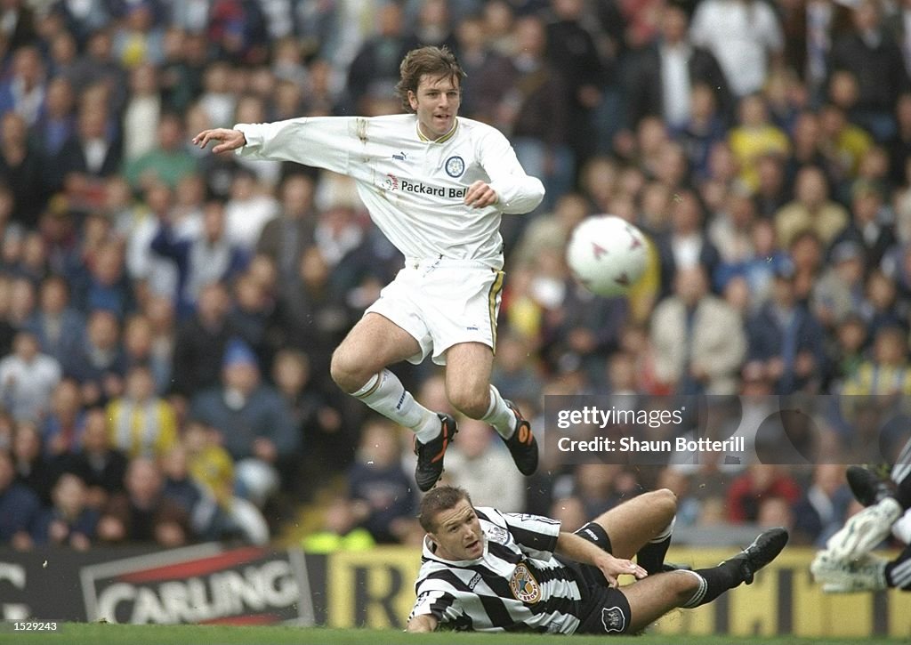 Lee Sharpe of Leeds United, off the groud, is tackled by Steve Howey