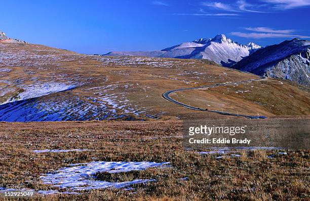 cars in the distance make their way up trail ridge road in the rocky mountains national park. - trail ridge road colorado - fotografias e filmes do acervo