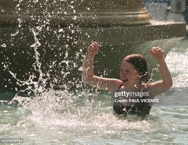 Clare Smith from South East London enjoys a water fight with his friends in a London fountain, 12 August as the continuing heatwave hits London and...