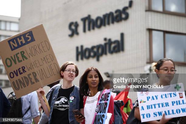 Junior doctors hold placards at a picket line outside St Thomas' Hospital in London on July 13, 2023 in the biggest walkout in the history of the...