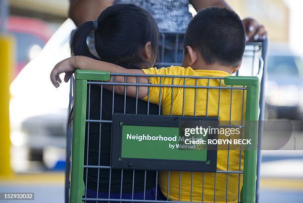 Danny Diaz , rides in a shopping cart with his sister Brianna Diaz as they arrive with their mother for the Grand Opening of the new Walmart...