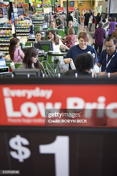 Cashiers ring up purchases on the opening day of the new Walmart Neighborhood Market in Panorama City, California, a working class suburb of Los...