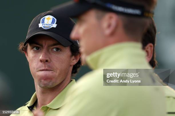 Rory McIlroy of Europe looks over at teammates Graeme McDowell and Ian Poulter during the Afternoon Four-Ball Matches for The 39th Ryder Cup at...