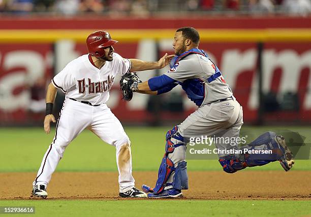 Adam Eaton of the Arizona Diamondbacks is taged out by catcher Welington Castillo of the Chicago Cubs in a run down during the seventh inning of the...