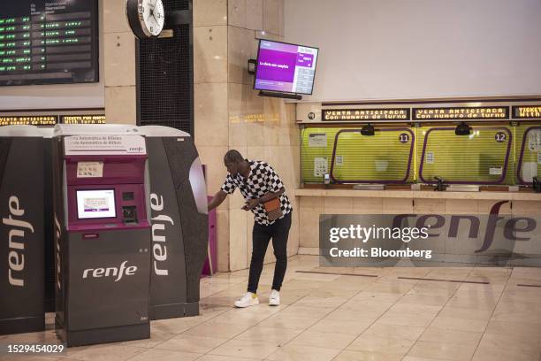 Traveler uses a self-service ticket machine of Renfe Operadora SC at Sants railway station in Barcelona, Spain, on Thursday, July 13, 2023. Spain's...