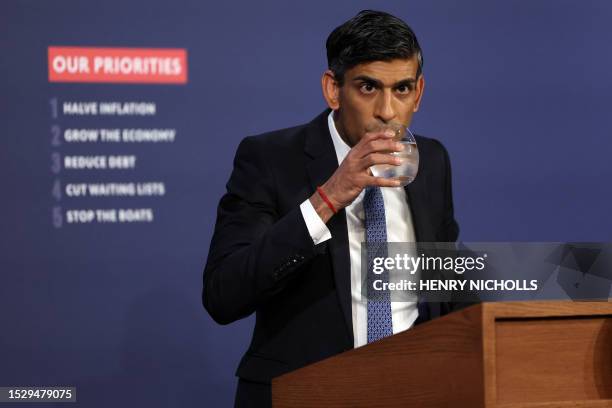 Britain's Prime Minister Rishi Sunak takes drink of water at a press conference at Number 9 Downing Street on public sector pay in London on July 13,...