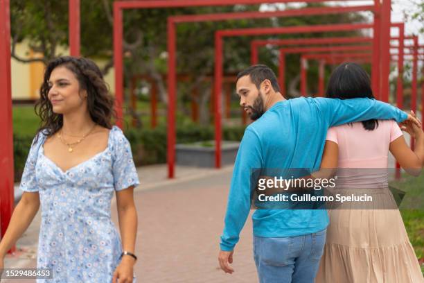 man with girlfriend turning around amazed at another woman - unrequited love stock pictures, royalty-free photos & images