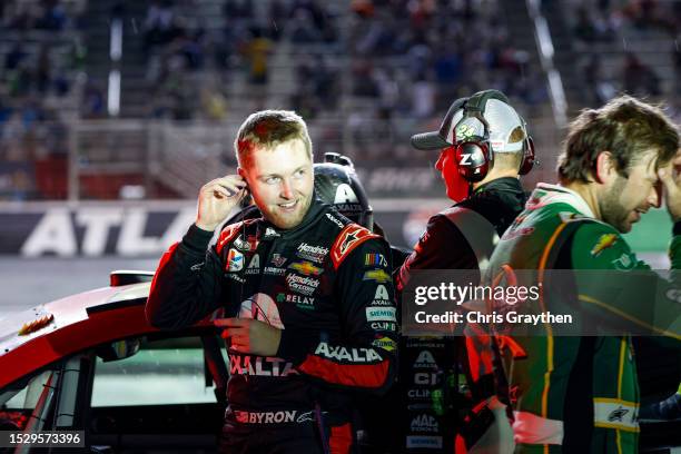 William Byron, driver of the Axalta Chevrolet, and Daniel Suarez, driver of the Quaker State Chevrolet, react to the weather delay of the NASCAR Cup...