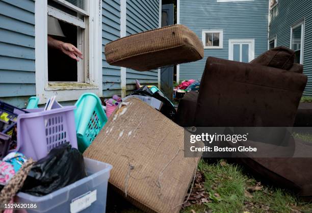 Johnson, VT Patrick Lafaso tosses couch cushions out of the window as he helps Jessica Anthony clean up from the historic flooding in Vermont that...