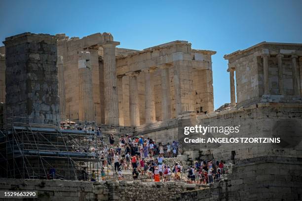 Tourists visit the Ancient Acropolis archeological site in Athens on July 13 as Greece hits high temperatures. Greece's national weather service EMY...