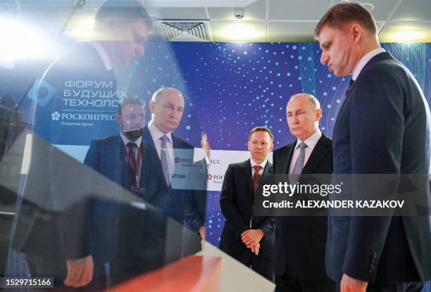 Russia's President Vladimir Putin listens to explanations as he visits an exhibition of advanced developments in the field of quantum technologies of...