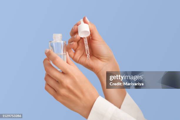 female hands hold a bottle of serum with a pipette. - retinol stock pictures, royalty-free photos & images