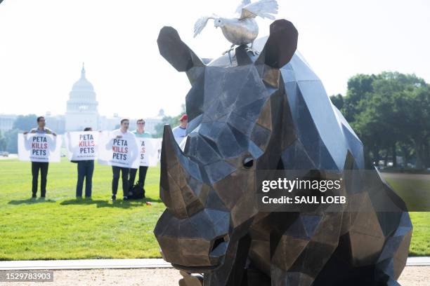 Protestors against PETA stand behind a collection of steel and aluminum sculptures by Washington statebased artist Quill Hyde, displayed during an...