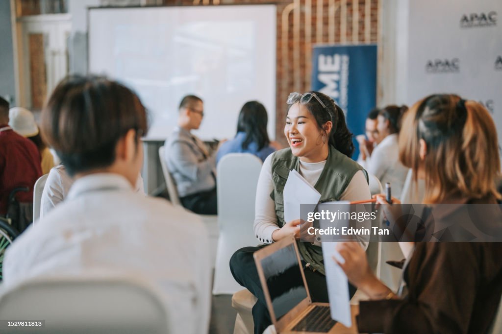 Team building, participantes de talleres asiáticos en discusiones en grupos pequeños, lluvia de ideas durante la clase de taller de negocios