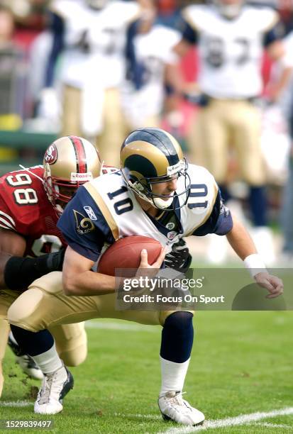 Marc Bulger of the St. Louis Rams gets sacked by Julian Peterson of the San Francisco 49ers during an NFL Football game November 2, 2003 at...