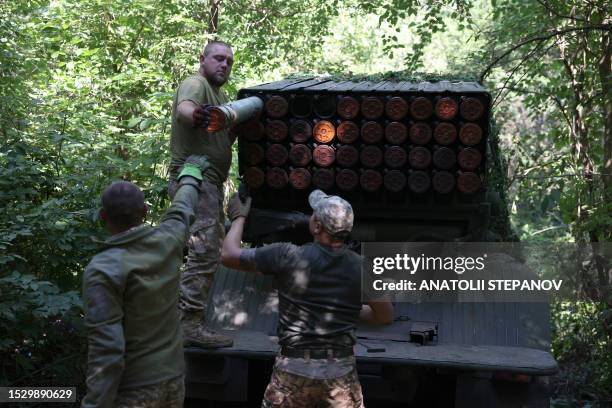 Ukrainian artillerymen load missiles onto a self-propelled 122 mm multiple rocket launcher BM-21 "Grad" near Bakhmut, Donetsk region, on July 13,...
