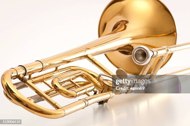 a closeup of the back of a golden trombone - brass band stock pictures, royalty-free photos & images