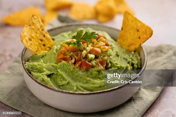 guacamole bowl with nachos - guacamole stock pictures, royalty-free photos & images