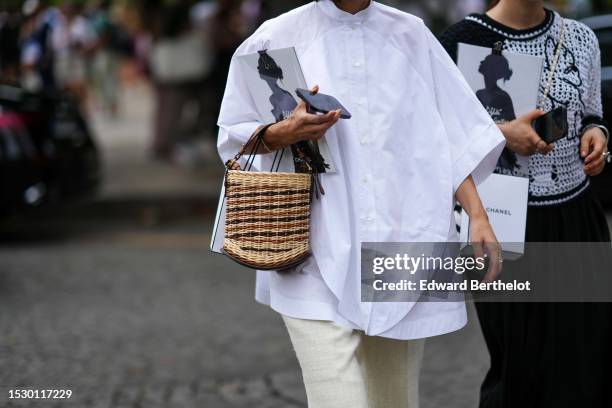 Guest wears a white oversized bat sleeves shirt, white latte fringed ankle suit pants, a beige with brown striped print pattern Pin Mini bucket Osier...