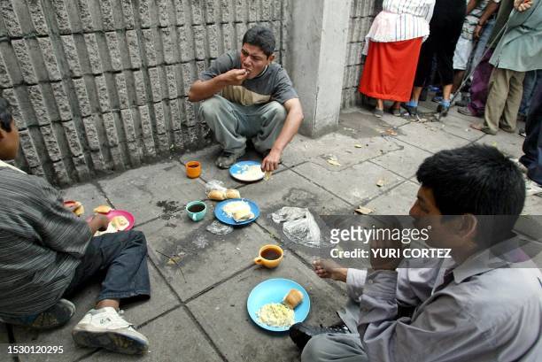 Edwin and two unidentified young people eat their breakfast provided by the catholic people from the "Saint Antony Church", 24 June 2003. Edwin and...