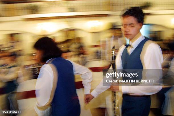 Year old Cristian Tapia who is completely blind is guided by his a friend to his place before starting a concert by a youth orchestra in Quito, 20...